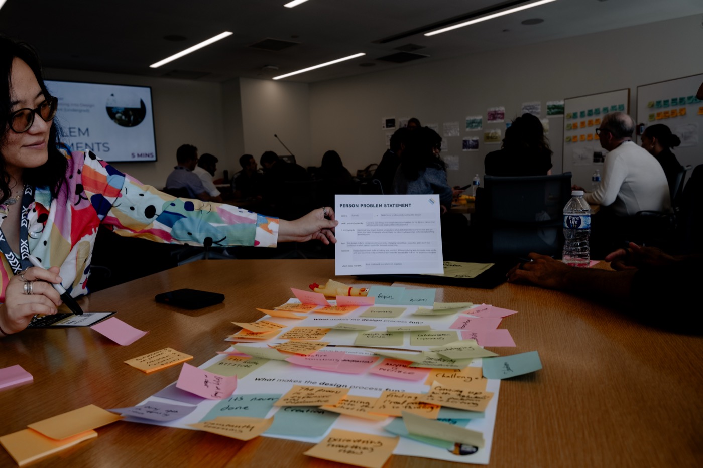 Hands sorting sticky notes during the service design jam