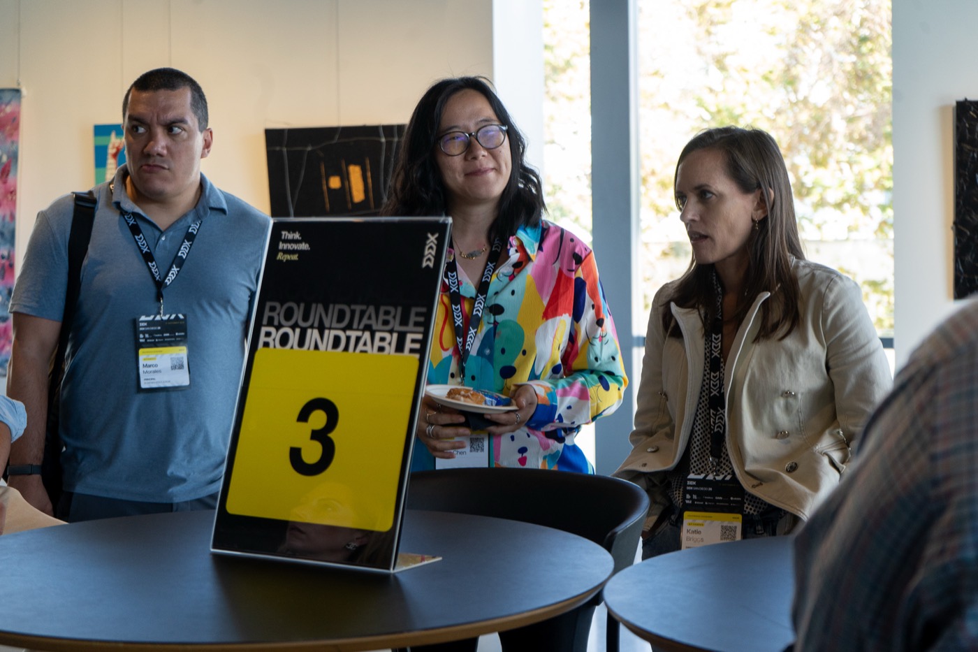 Attendees gathered at a numbered table talk during a break